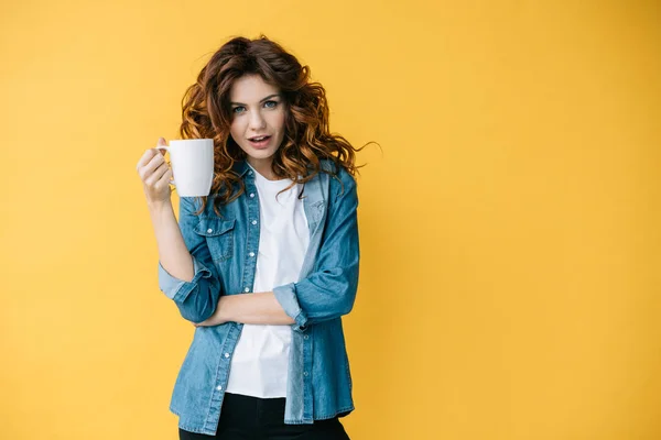 Vrolijke Krullend Vrouw Die Beker Vasthoudt Naar Camera Oranje Kijkt — Stockfoto