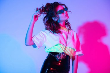 aydınlatma ile mor kıvırcık saç dokunmadan güneş gözlüğü çekici kız  