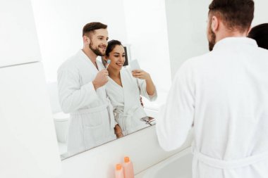 neşeli kadın diş fırçası tutan mutlu adam ile fotoğraf çekmek seçici odak 