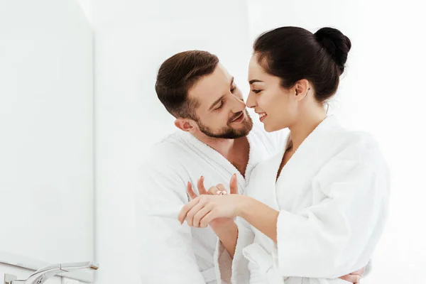 Cheerful Bearded Man Looking Happy Woman Applying Hand Cream — Stock Photo, Image