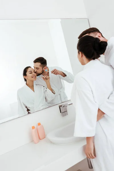 Uomo Barbuto Baciare Guancia Donna Allegra Guardando Specchio Bagno — Foto Stock