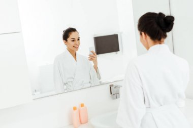 banyoda fotoğraf çeken çekici ve neşeli genç kadının seçici odak 