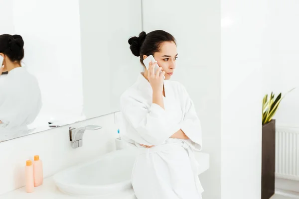 バスルームでスマートフォンで話す魅力的な若い女性の選択的な焦点 — ストック写真