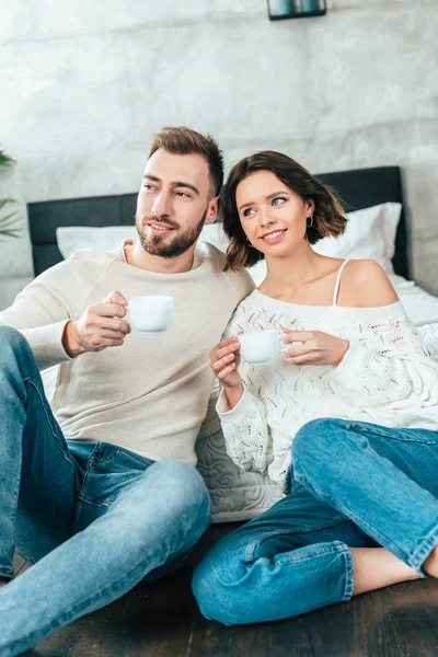 Gelukkige Man Vrolijke Vrouw Zittend Vloer Het Houden Van Kopjes — Stockfoto