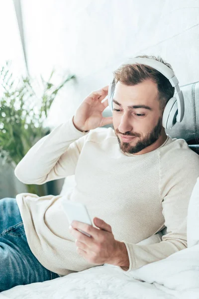 Fröhlicher Bärtiger Mann Der Beim Musikhören Über Kopfhörer Aufs Smartphone — Stockfoto