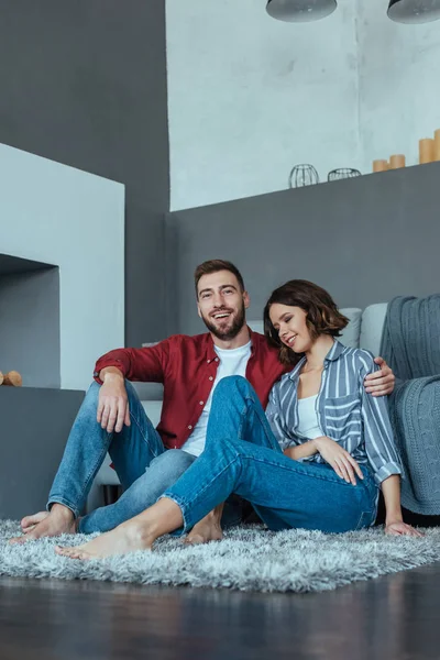 Hombre Feliz Sonriendo Mientras Está Sentado Alfombra Con Mujer Atractiva —  Fotos de Stock