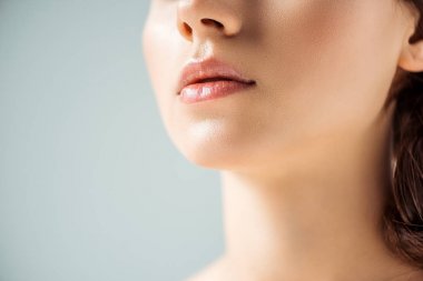 gri arka planda parlak dudaklar ile genç kadının kırpılmış görünümü