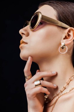 güneş gözlüğü genç çıplak kadın profili, altın küpe, yüzük ve kolye siyah izole