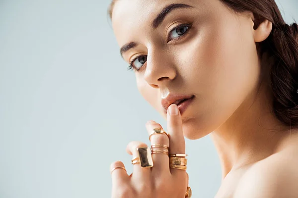 Young Woman Shiny Makeup Golden Rings Touching Lips Isolated Grey — Stock Photo, Image