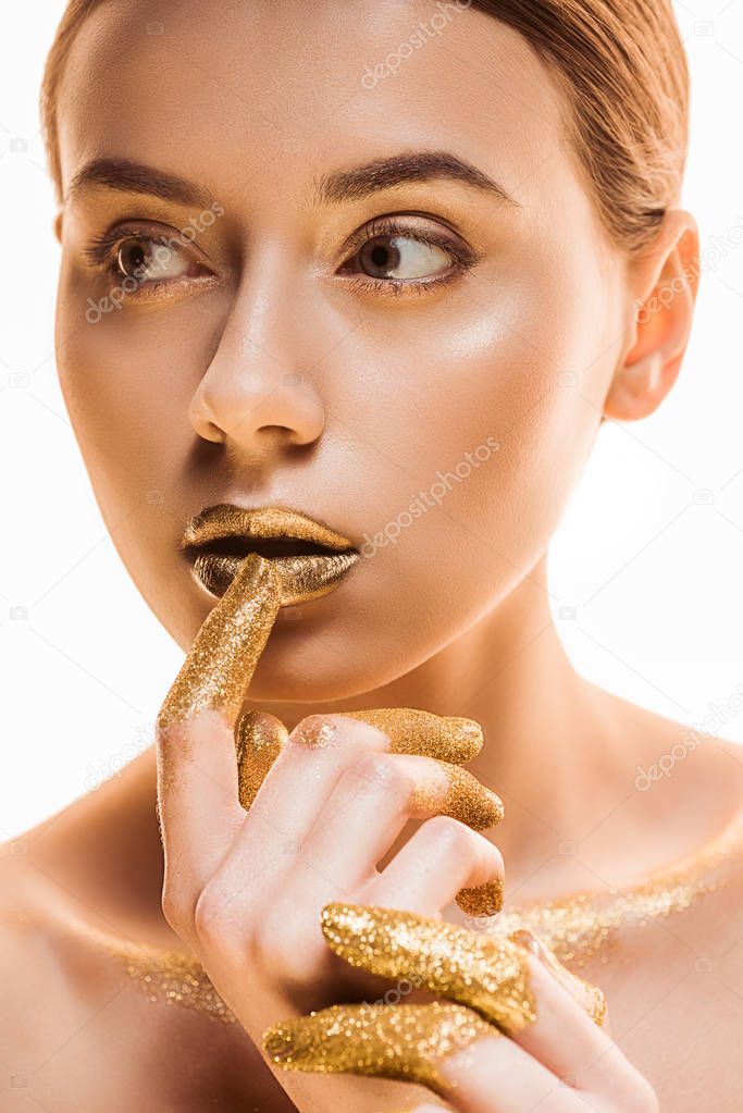 young beautiful woman with golden makeup and sparkles on fingers touching lips isolated on white