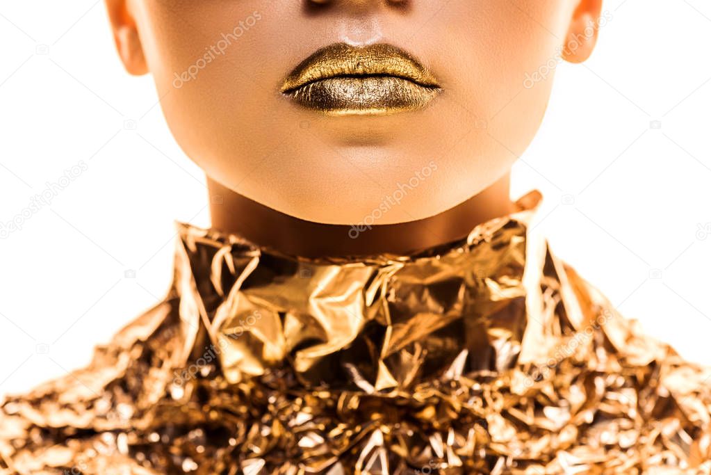 cropped view of young woman with golden lips in golden foil isolated on white