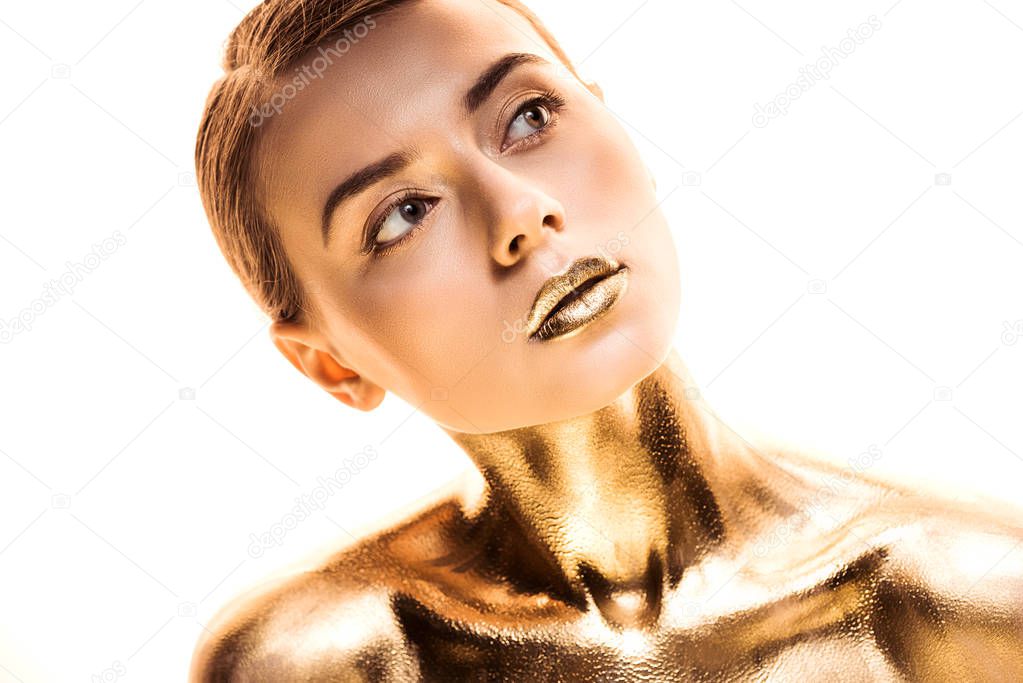 naked young woman painted in golden looking away isolated on white