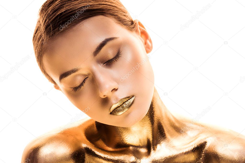 young naked woman with closed eyes painted in golden isolated on white