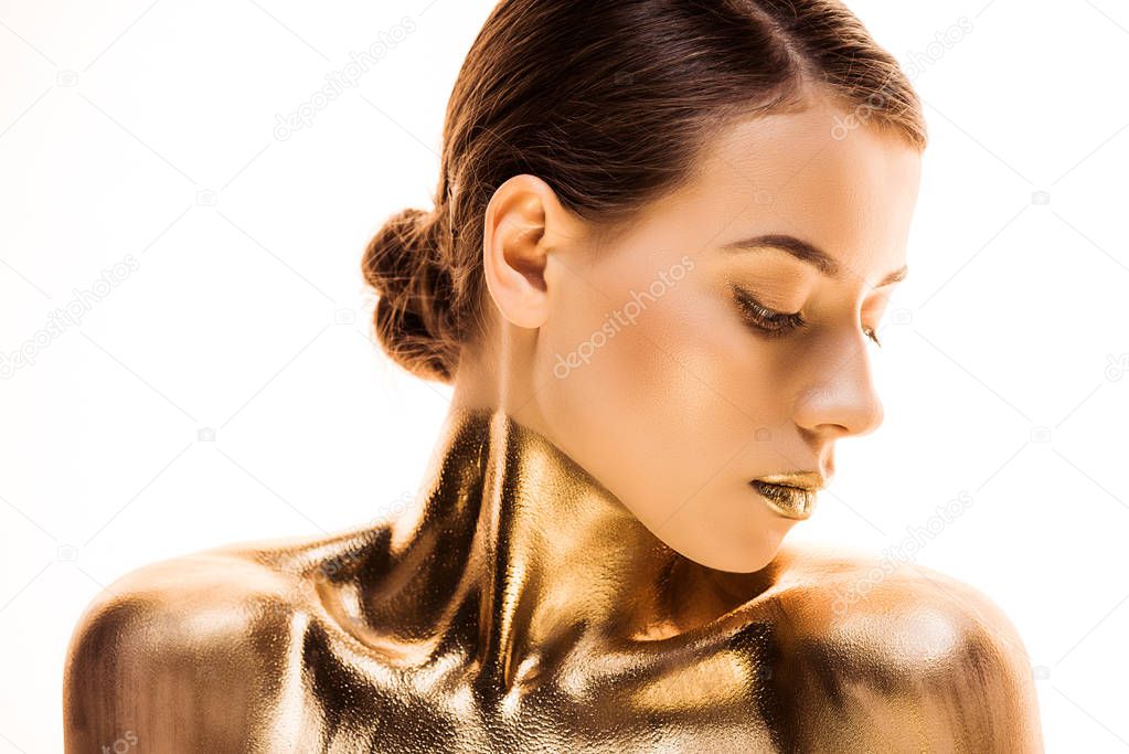 portrait of nude young woman painted in golden isolated on white