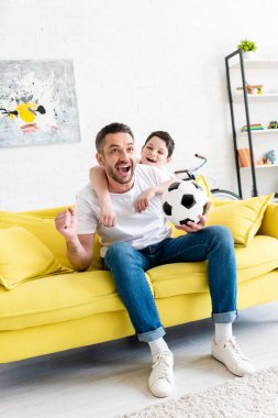 heyecanlı baba ve oğul spor maçı izlerken ve Oturma Odası tezahürat