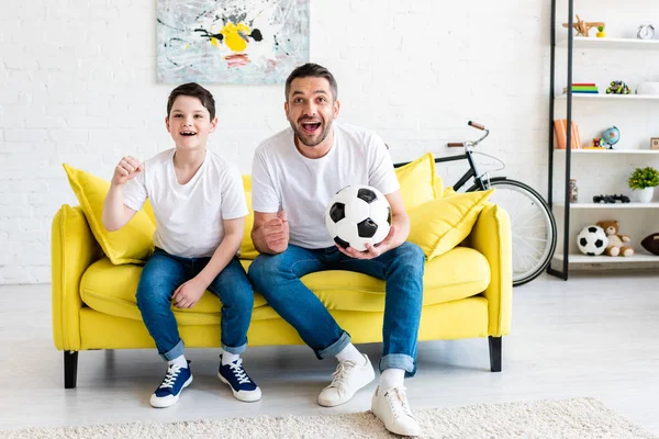 Pai Filho Torcendo Enquanto Assiste Jogo Esportes Sofá Com Bola — Fotografia de Stock