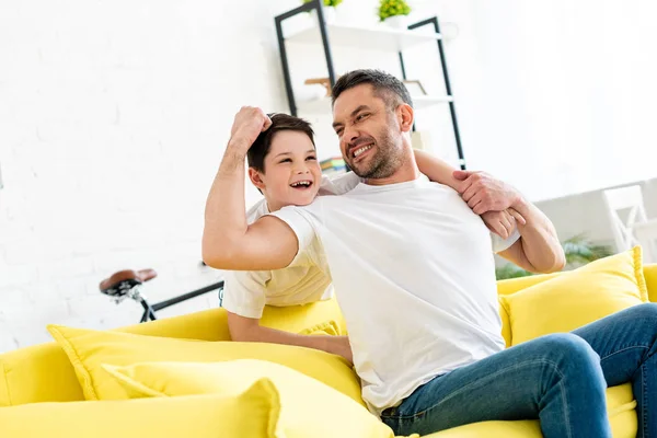 Son Hugging Happy Father Sitting Couch Home — Stock Photo, Image