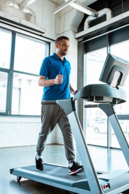 spor salonunda koşu bandı üzerinde çalışan yakışıklı adam