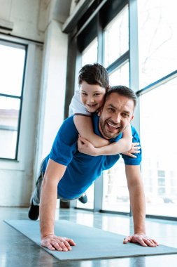 mutlu baba spor salonunda geri oğlu ile egzersiz kadar itme yapıyor