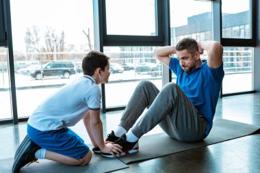 oğlu fitness mat oturan ve egzersiz kadar oturmak yapan baba yardım