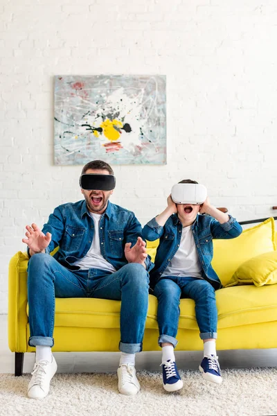 Chockad Far Och Son Headset Upplever Virtuell Verklighet Soffan Hemma — Stockfoto