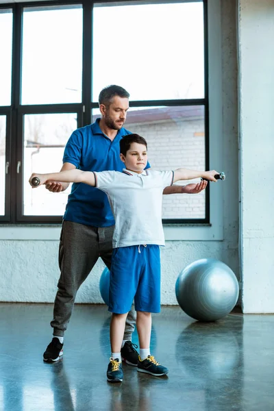 Padre Ayudando Hijo Hacer Ejercicio Con Pesas Gimnasio — Foto de Stock