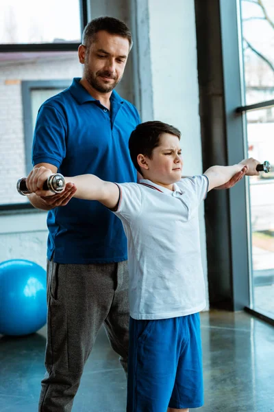 Padre Ayudando Hijo Hacer Ejercicio Con Pesas Gimnasio — Foto de Stock