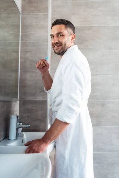 Handsome Man Bathrobe Looking Camera While Brushing Teeth Morning Routine — Stock Photo, Image