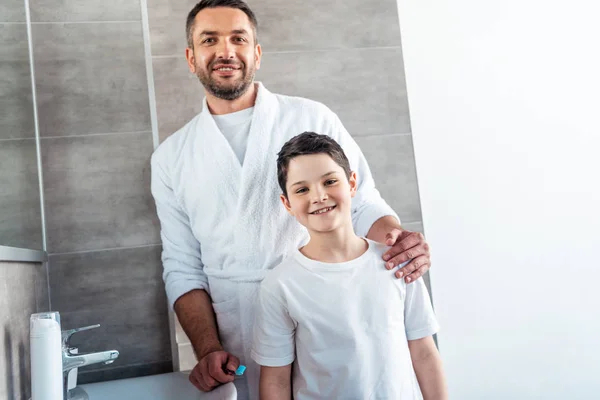 Sonrientes Padre Hijo Pijama Mirando Cámara Baño — Foto de Stock