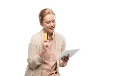 Beyaz Dijital Tablet İzole kullanarak kredi kartı ile gülümseyen orta yaşlı kadın
