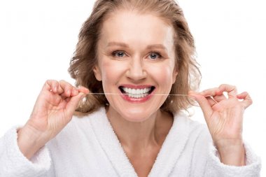 diş ipi Kullanan orta yaşlı kadın Beyaz Üzerinde Izole