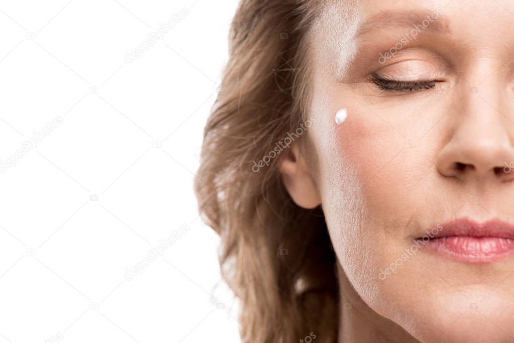 Cropped view of mature woman with cosmetic cream on face Isolated On White