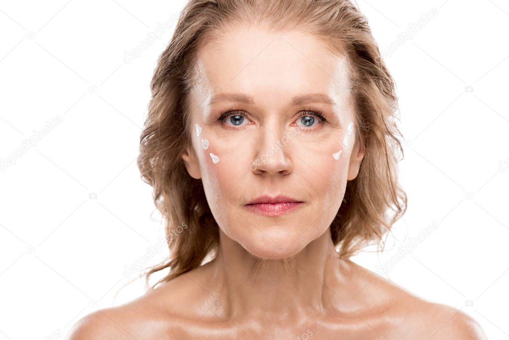 mature woman with cosmetic cream on face looking at camera Isolated On White