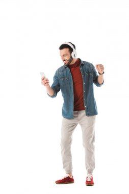 mutlu yakışıklı adam kulaklık müzik dinleme ve beyaz izole akıllı telefon kullanarak