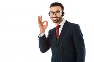 kulaklık yakışıklı çağrı merkezi operatörü kameraya gülümseyen ve beyaz izole tamam jest gösteren