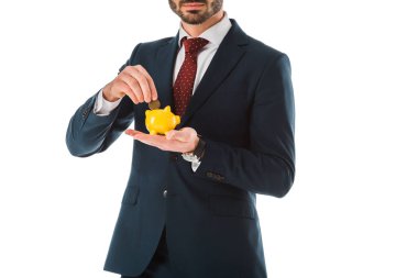 cropped view of businessman putting coin into piggy bank isolated on white clipart