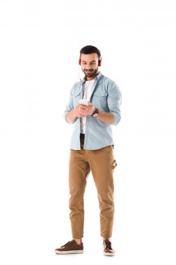 kulaklık gülümseyen adam müzik dinleme ve beyaz izole akıllı telefon kullanarak