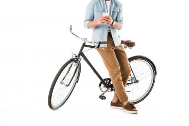 beyaz izole akıllı telefon kullanarak bisiklet ile yetişkin adam kısmi görünümü