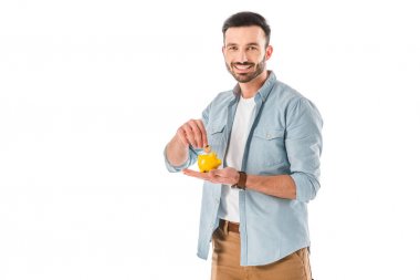 neşeli sakallı adam kumbara içine sikke koyarak ve beyaz izole kamera bakıyor