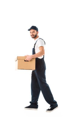 yakışıklı gülümseyen teslimat adam karton kutu taşıyan ve beyaz izole kamera bakıyor