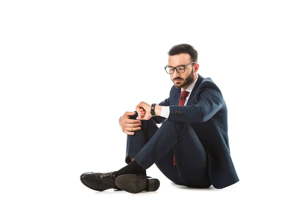 Pensativo Hombre Negocios Mirando Reloj Mientras Está Sentado Sobre Fondo — Foto de Stock