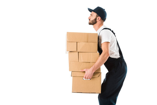 side view of serious delivery man carrying cardboard boxes isolated on white