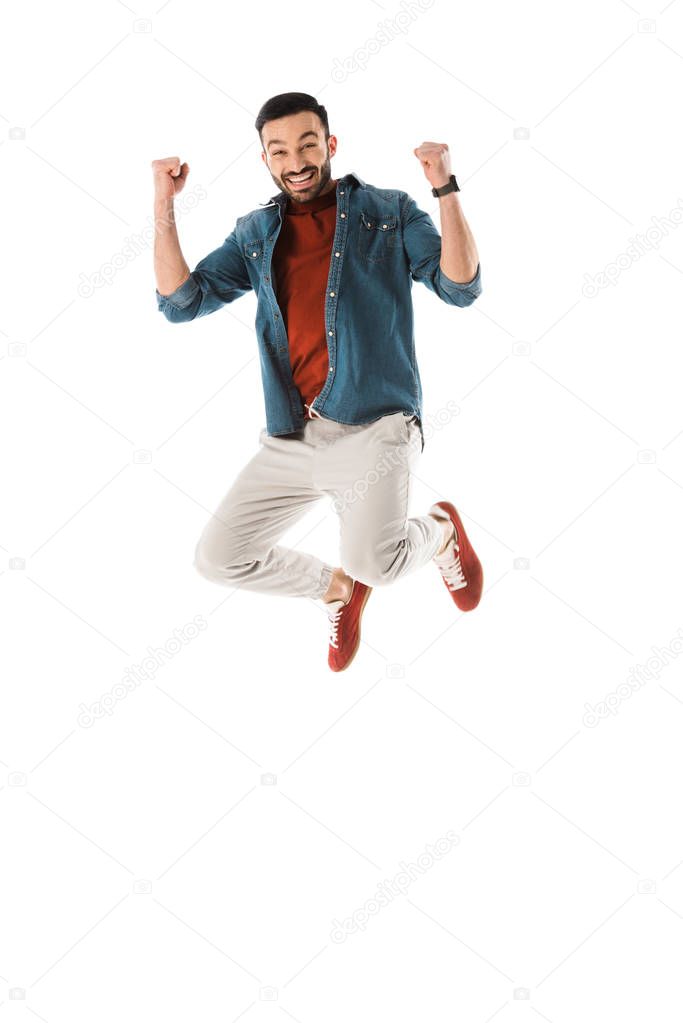 happy man jumping and showing winner gesture isolated on white