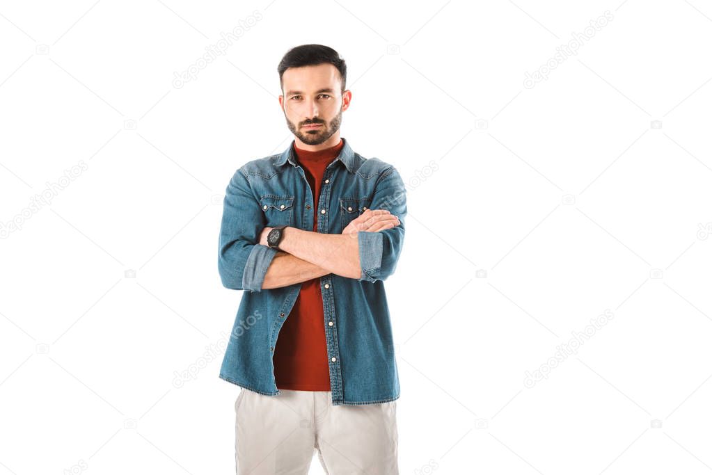 serious handsome man standing with crossed arms and looking at camera isolated on white