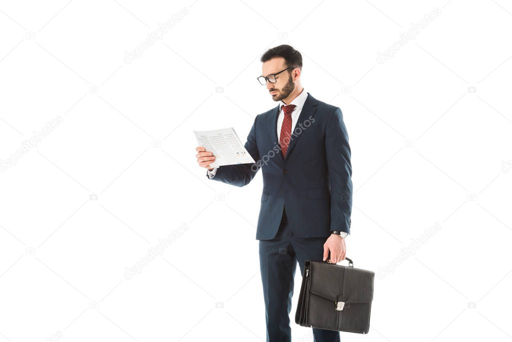 concentrated businessman with briefcase reading newspaper isolated on white