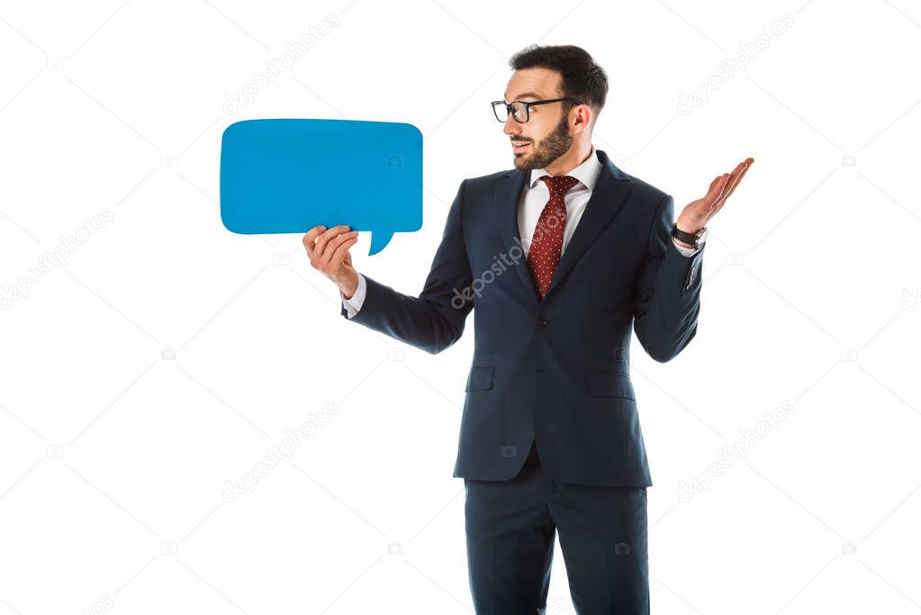 discouraged businessman showing shrug gesture and looking at speech bubble isolated on white