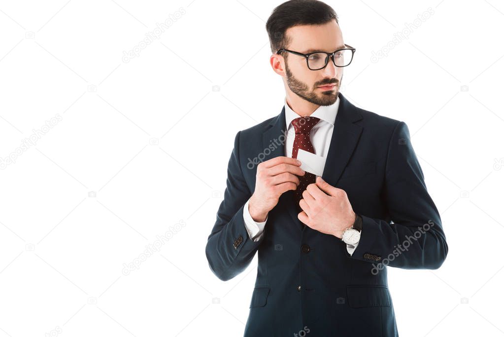 serious businessman getting business card out of jacket and looking away isolated on white