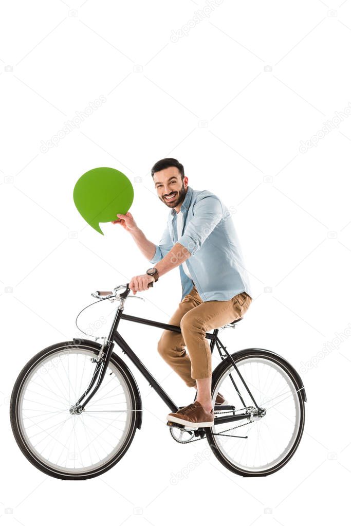 cheerful bearded man riding bicycle while holding thought bubble isolated on white