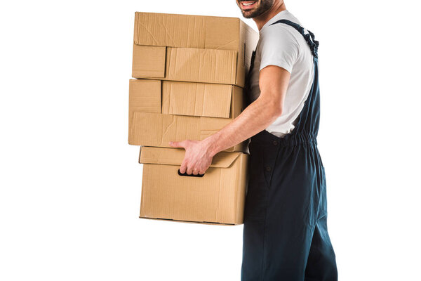 partial view of delivery man in overall carrying cardboard boxes isolated on white