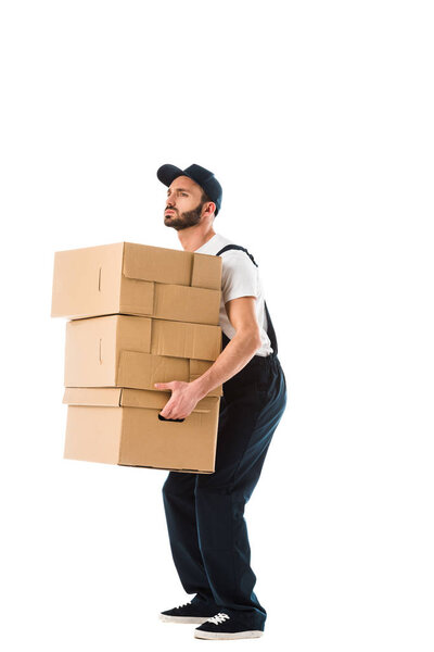 handsome serious delivery man carrying carton boxes isolated on white